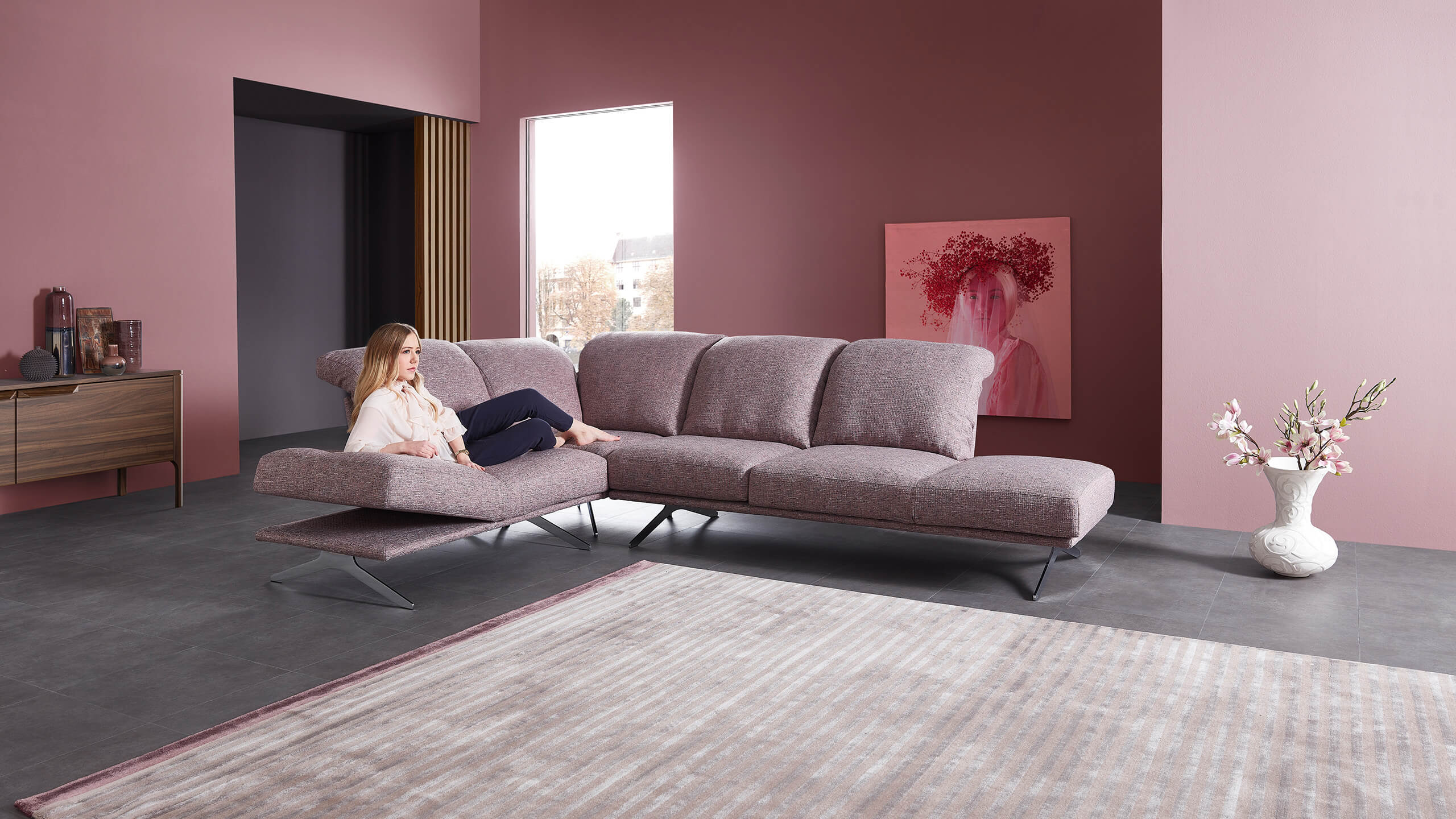 Cilia Ecksofa mit liegender Frau auf angewinkelter Armlehne