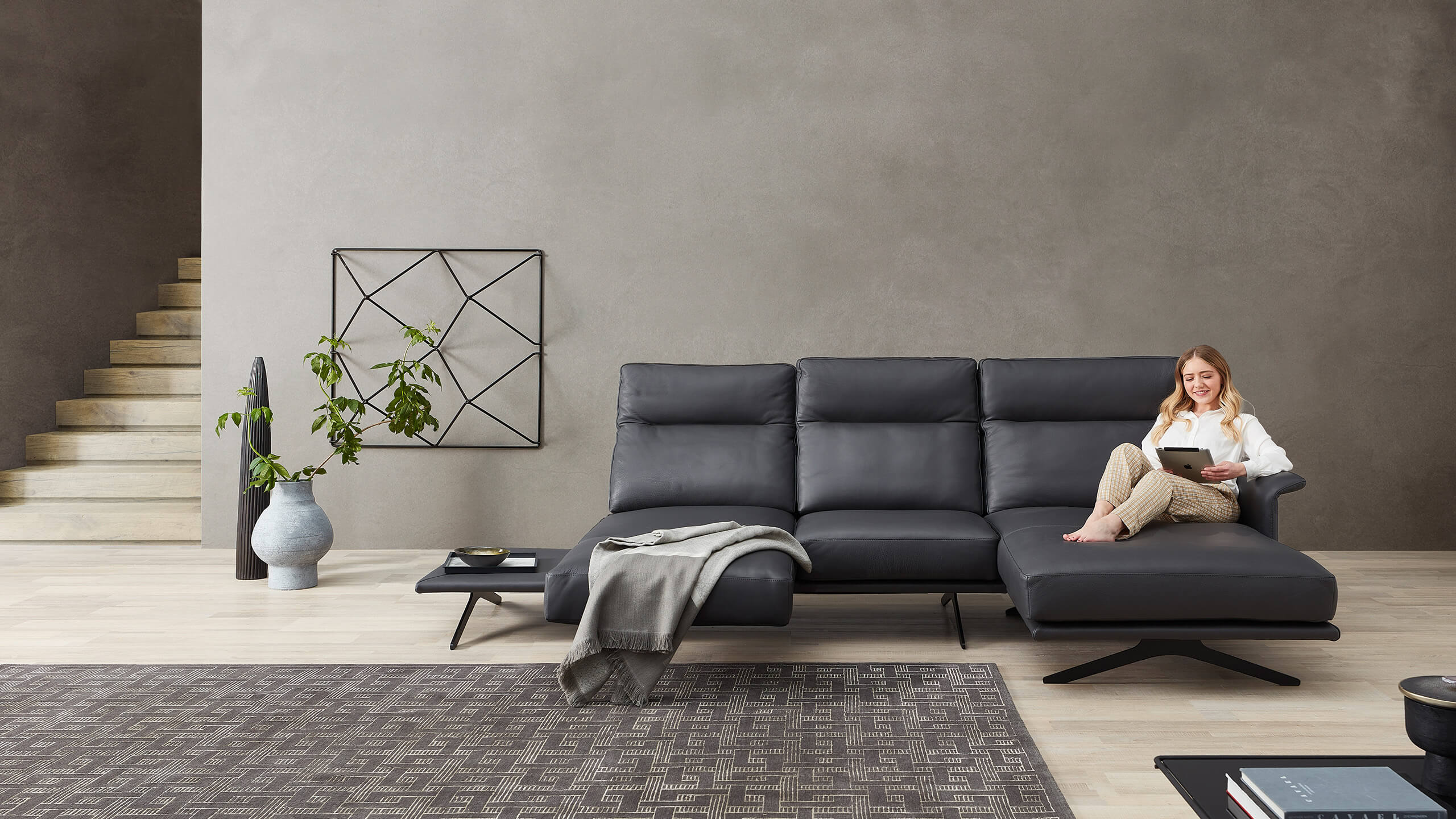 Cilia Ledersofa mit Frau auf Longchair und ausgezogenem Dresitz