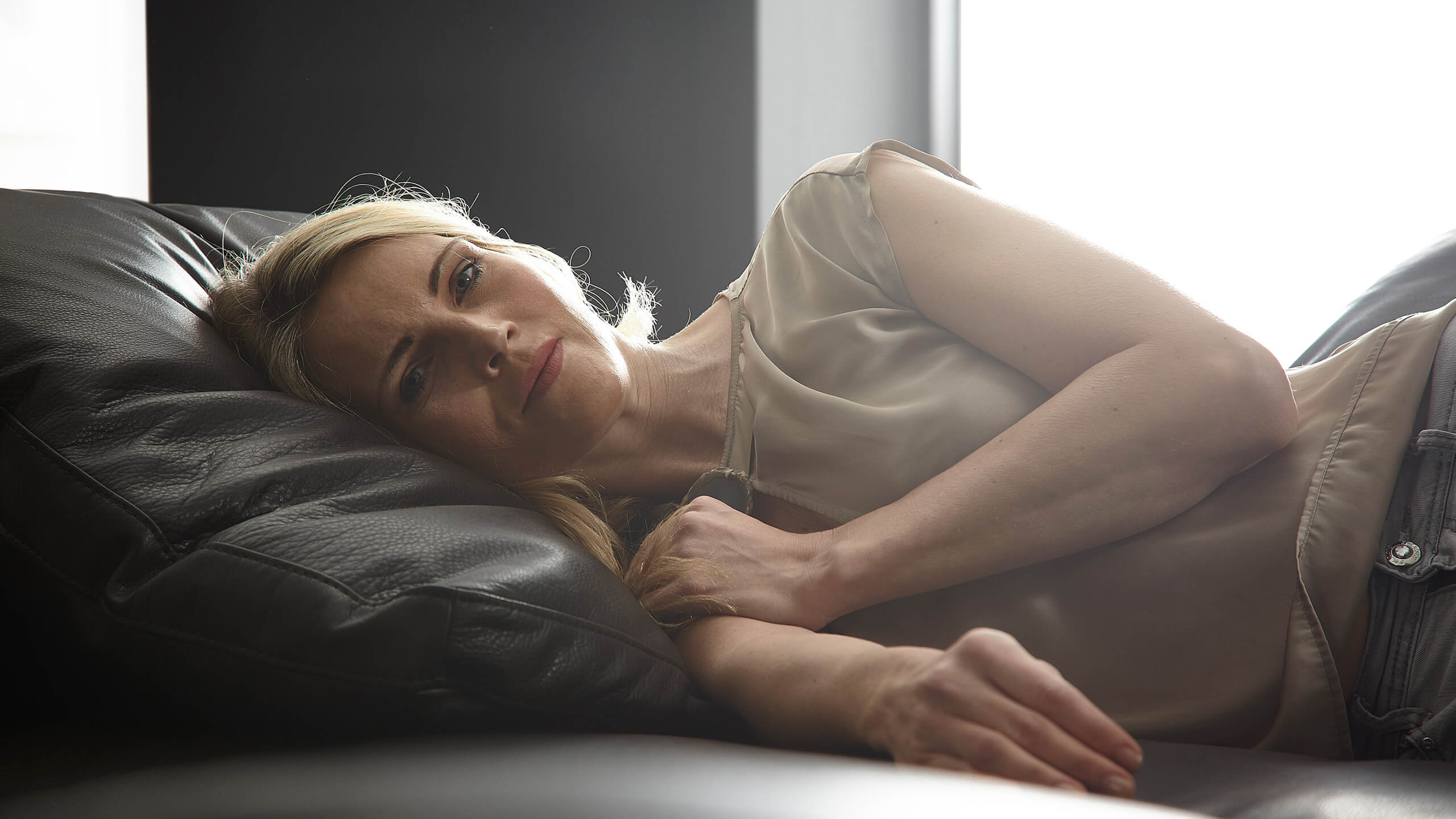 Liegende Frau auf Lederkissen